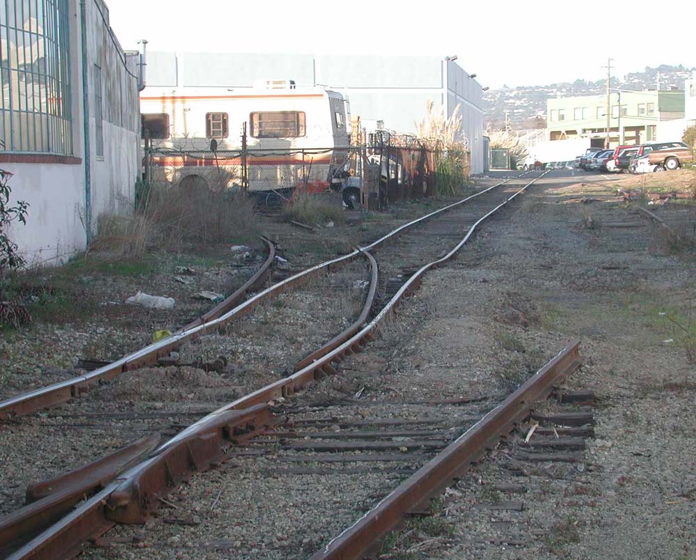 LSI_lead
Long ago this was the Ninth Street Red Train route. Up until a few years ago this was the lead to LSI in Emeryville. Scene looking east from Powell St. These tracks still exist as of this date (12/7/02). LSI is now gone. <i>Courtesy of John Stashik</i>
